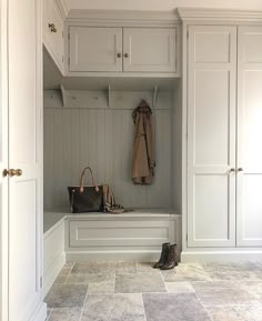 a white closet with two coats hanging on the wall