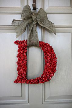 a wreath with the letter d hanging on a door