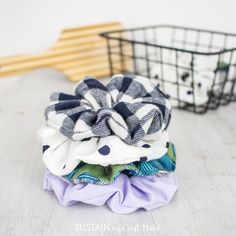 a pile of cloths sitting on top of a wooden floor next to a basket