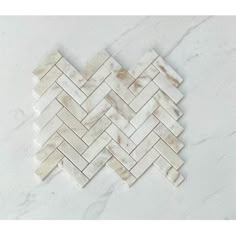 white marble herrings with brown veining on the backsplash, in an angled pattern