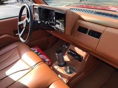 an interior view of a car with brown leather seats and dashboard, including the center console