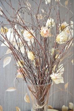 a vase filled with branches and flowers on top of a table