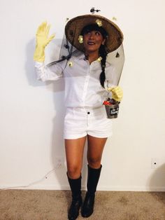 a woman wearing a straw hat and white shorts with her hands up in the air