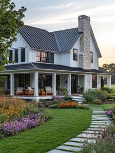 a large white house with lots of flowers in the front yard