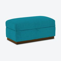 a blue ottoman sitting on top of a white floor