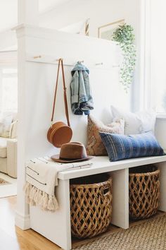 a white bench with baskets and hats on it