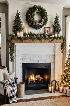 a living room decorated for christmas with candles and wreaths on the fireplace mantel