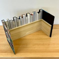 there is a book shelf made out of cd's in the shape of a corner