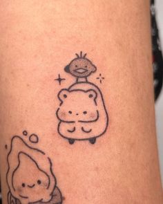 a small tattoo on the leg of a person with a bear and an owl sitting on top of each other