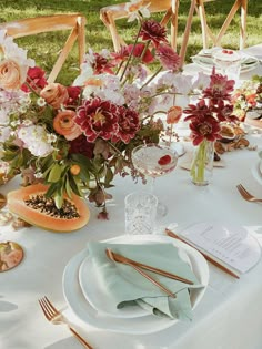 the table is set with flowers and place settings