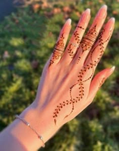 a woman's hand with henna tattoos on it