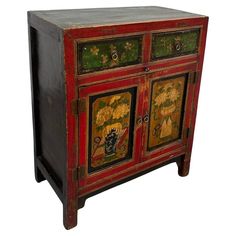 an old red and black cabinet with paintings on it