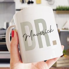 a person holding a coffee mug with the word dr in black and white on it