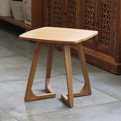 a wooden stool sitting on top of a floor