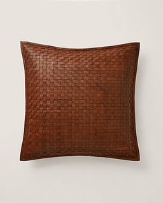 a brown leather pillow on a white wall