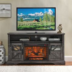 a flat screen tv sitting on top of a wooden entertainment center next to a fire place