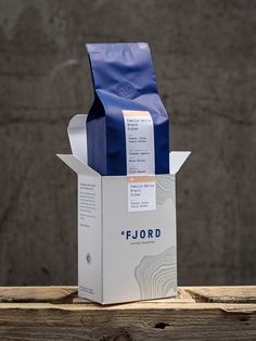 a coffee bag sitting on top of a wooden table next to a paper bag with the word fiord written on it