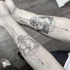 two people with tattoos on their arms are holding each other's hands and looking at the map