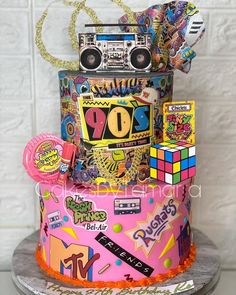 a colorful cake decorated with stickers and music equipment on it's top tier