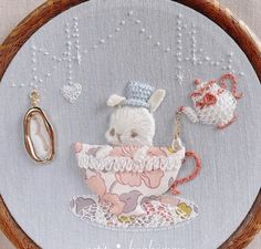 a white teddy bear sitting in a teacup