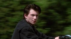 a young man riding on the back of a motorcycle