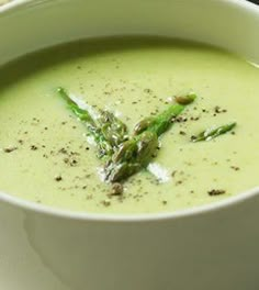 there is a bowl of soup with asparagus in it