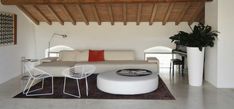 a living room with white furniture and wooden ceiling