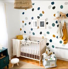 a baby's room with polka dots on the wall