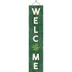 a welcome sign hanging from the side of a wooden pole with shamrocks on it