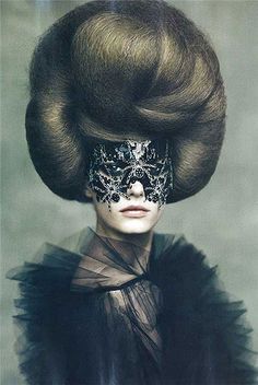 a woman wearing a mask with hair in the shape of a wig