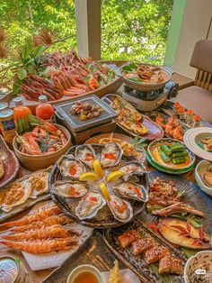 a table filled with lots of different types of food on plates and serving trays