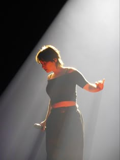 a woman standing in front of a spotlight