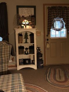 a living room filled with furniture next to a door and window covered in plaid curtains