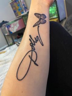 a person with a tattoo on their arm that reads, love and butterflies in cursive writing