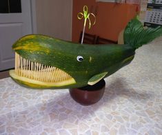 a cucumber with a toothbrush shaped like a fish on top of it