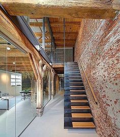 the inside of a building with stairs leading up to an open floor plan and glass walls