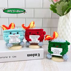 two small crocheted animals sitting next to each other on top of a box