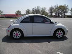 a small white car parked in a parking lot