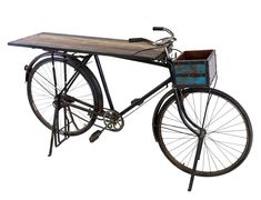 an old fashioned bicycle with a wooden table on the back