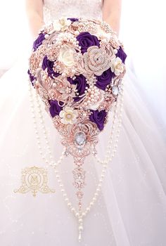 a bridal holding a purple and white bouquet with pearls, brooches and other accessories