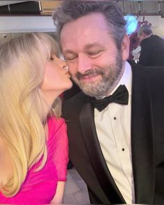 a man in a tuxedo kissing a blonde haired woman