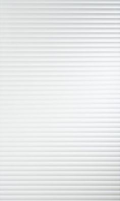 a white wall with vertical blinds on it