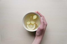 a person holding a white bowl filled with lemon slices