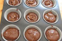 cupcakes with chocolate frosting in a muffin tin