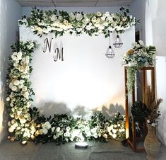 the backdrop is decorated with white flowers and greenery