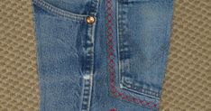 a pair of blue jeans with red stitching on them