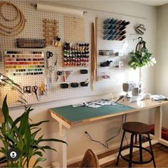 a sewing room with lots of crafting supplies on the wall and hanging pegs