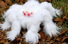 a white stuffed animal with red eyes laying on the ground