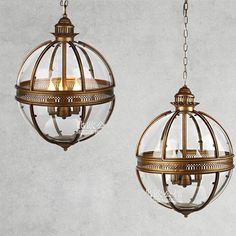 two hanging lights with glass globes and chains on the sides, one is gold