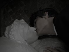 a man and woman are kissing in the dark